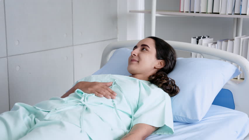 Hispanic woman lying in a hospital bed to do physical therapy Testing breathing in and out From the advice of physical therapist Medical assistant, orthopedic specialist In hospital examination room Royalty-Free Stock Footage #1109507807