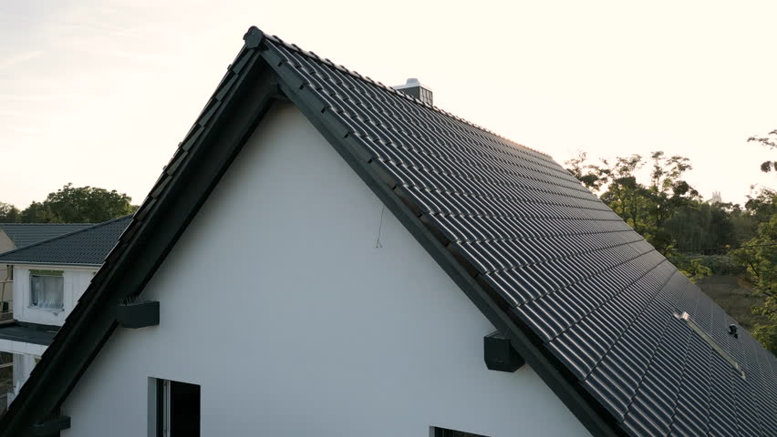 Sunset over the roof of a detached house in a suburban area
