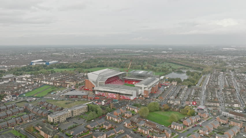 Cloudy Colosseum: Fly over Anfield Stadium as rolling clouds paint the sky, casting soft shadows on the home of Liverpool FC.
 Royalty-Free Stock Footage #1109513509