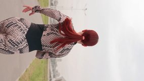 Vertical Video, Slim Athletic Woman with Red Hair in Sports Overalls Run. Girl Athlete is Engaged in Jogging Outdoors in the Daytime. Female Runner Trains by Running. Slow Motion.
