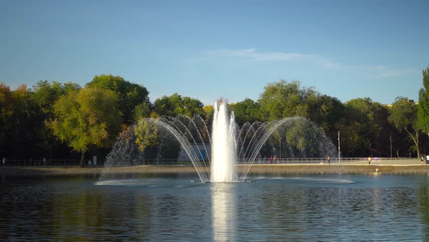 A fountain in a park in the middle of a lake. Autumn view of the fountain.