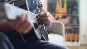 man playing guitar at home.