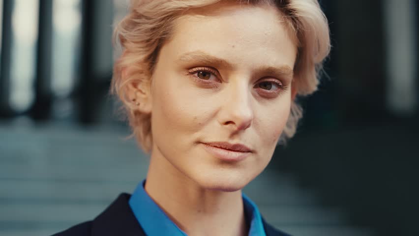 Close up portrait of caucasian business lady with natural beauty looking at camera while standing over background of glassy skyscrapers. Concept of career, confidence and success. | Shutterstock HD Video #1109539571