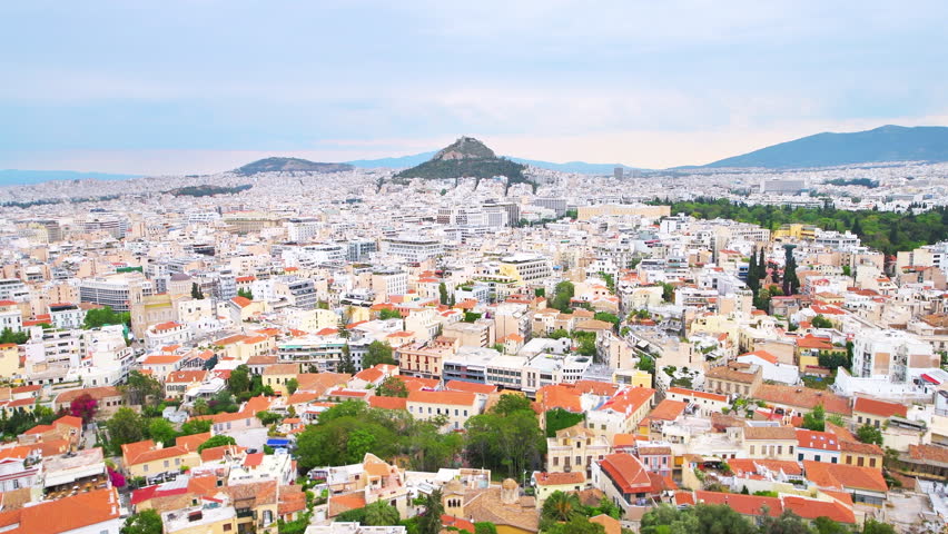 Athens Greece street cityscape high angle aerial Acropolis view on roof rooftop buildings, mount Lycabettus hill, temple of Olympian Zeus panning shot