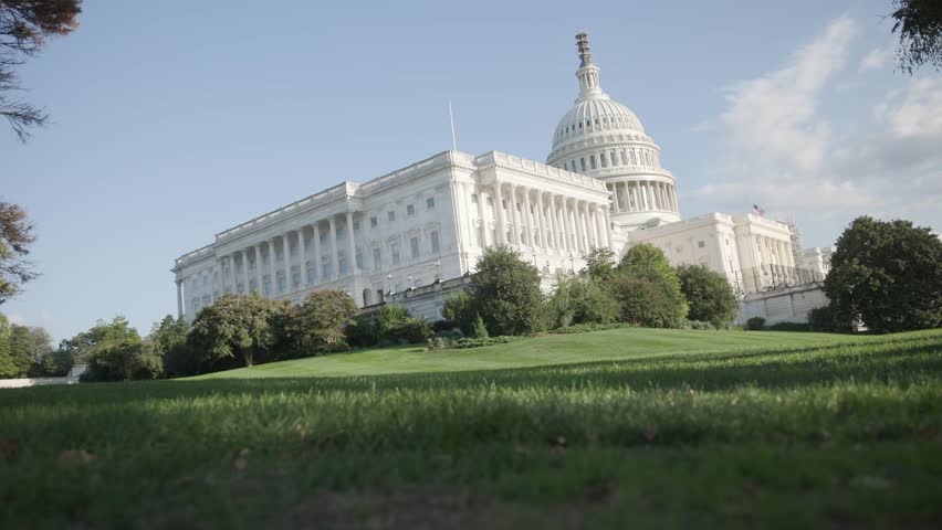 Establishing exterior shot during the day time and view of white capital building on United States of American mall with congress senators and house of representatives chambers inside