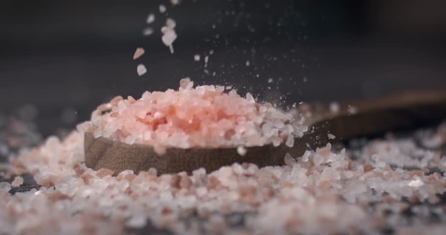 Himalayan pink salt in a wooden is used to flavor food. Due mainly to marketing costs, pink Himalayan salt is up to twenty times more expensive than table or sea salt. Royalty-Free Stock Footage #1109556939