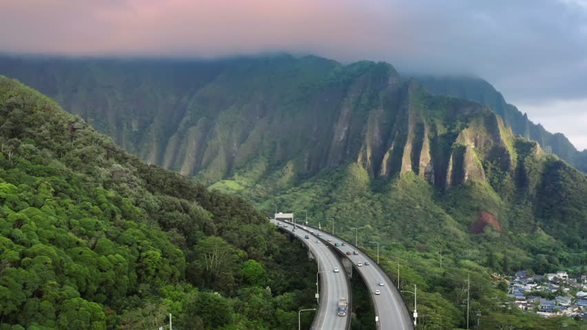 Scenic route on Oahu Hawaii island at golden sunrise. Interstate H3 passing through majestic green Koolau Mountains with Trans-Koolau twin tunnels. Aerial along highway with epic nature landscape view Royalty-Free Stock Footage #1109565117