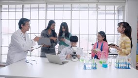 Atmosphere in elementary school science classrooms. Science teacher is training students to experiment. Male and female students  learning together with friends. that uses laptop and digital tablet  - Powered by Shutterstock - Get 15% off with code: PIKWIZARD15