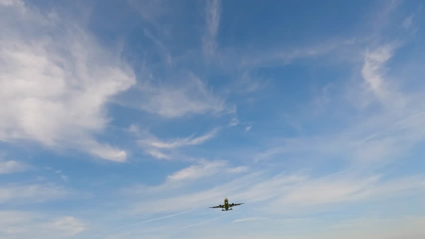 Large airliner with passengers on blue sky is landing on landing strip at airport. 4K Airplane impressive landing flying overhead. 