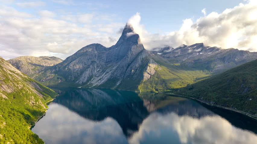 Drone hyperlapse of thin cloud around iconic Stetind mountain, fjord reflection Royalty-Free Stock Footage #1109585725