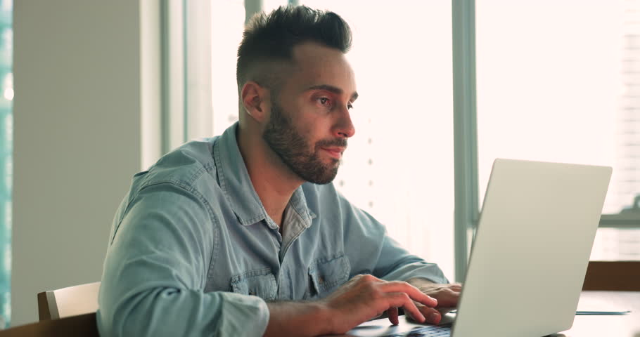 Handsome Hispanic man sit at desk with laptop, websurfing page, browse internet, search helpful information, spend free time on internet, scroll social media work at home office. Telework, modern tech Royalty-Free Stock Footage #1109599871