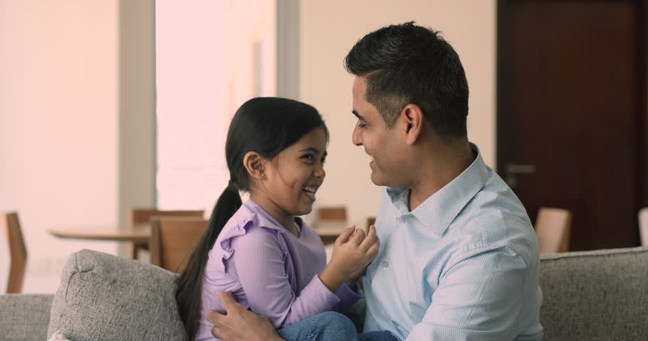 Indian man, loving dad tickling his adorable cheerful little 5s daughter, cheery family spend leisure at home, sit on sofa enjoy funny playtime and time together. Happy fatherhood, custody, childcare Royalty-Free Stock Footage #1109599941
