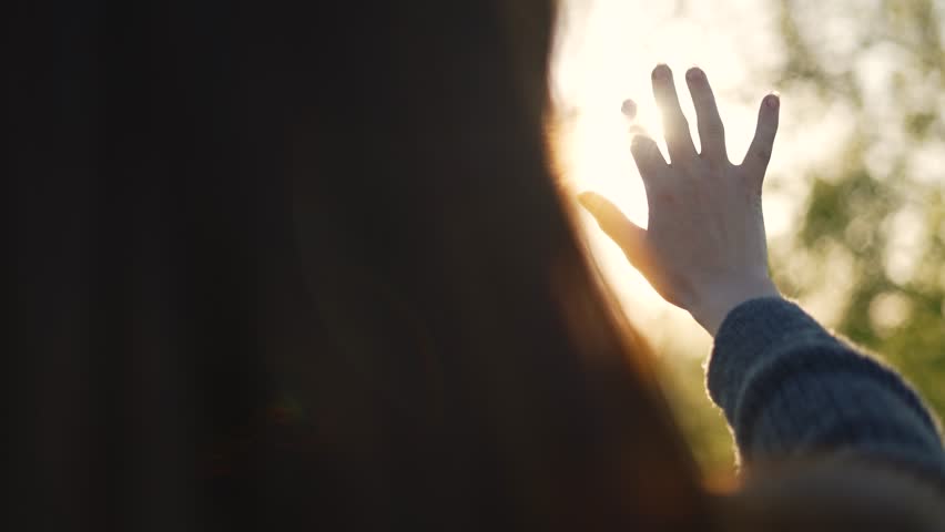 Hand of happy girl at sunset. Sunset between the hands of girl. Happy girl with long hair dreamily stretches out her hand to sun. Child's dream hand to the sun. happy family concept. Freedom in nature Royalty-Free Stock Footage #1109605575