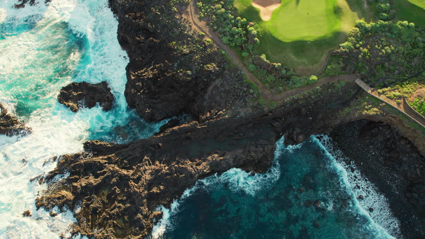 Aerial view of a golf club field at sunset on Tenerife Island, Canary Islands, Spain. Golf course on the rocky coast of Tenerife island, picturesque scene with sunset light. Luxury destination scene