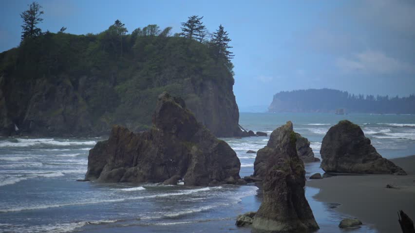 People on the shore, view of rocks in the water of the Pacific Ocean in Olympic NP, Washington
