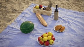 Watermelon, apples, lemons, baguette, croissants, bottle of wine with glasses, pears, plums and pineapple in wicker basket on sandy ocean beach. Picnic tablecloth with food and drink at sea shore - Powered by Shutterstock - Get 15% off with code: PIKWIZARD15