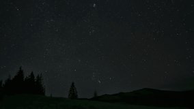 Time lapse of moving stars over the mountains in the night sky. Starry night background. Epic video 4K