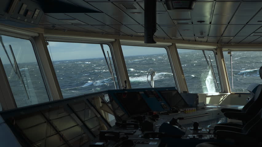 Storm in ocean. Navigation bridge of ship inside. Control panel in foreground. Strong pitching. Sea view from wheelhouse windows. Foam on high waves. Royalty-Free Stock Footage #1109613005