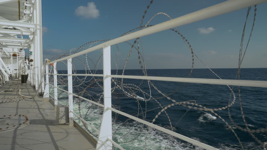 Barbed wire is fixed on railing of vessel open deck. Protection from pirates. Fire monitor and hose on rail. Pirate high risk area in sea. Royalty-Free Stock Footage #1109613015