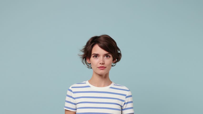 Young promoter woman wear striped t-shirt casual clothes pointing indicate index finger aside on workspace area copy space mock up isolated on pastel plain light blue cyan background studio portrait Royalty-Free Stock Footage #1109616165
