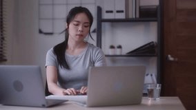 Young Asian woman hard working with documents at her using laptop computer with analytical charts and graphs at her home, work from home concept - Powered by Shutterstock - Get 15% off with code: PIKWIZARD15