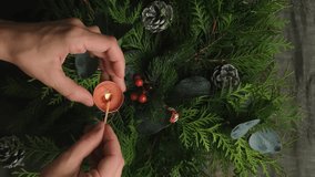 Vertical video. Christmas table set. Woman lights candle to decorate Christmas dinner table. 