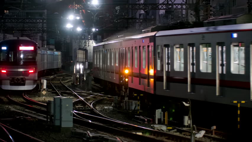 Driver view of Japanese commuter express train during the evening rush hour with passenger waiting to board on the platform