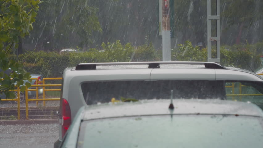 Hail torrential rain with massive hail. Assaults destroying everything in his path. Some cars protected from calls. Inside the car, scary sound of calls falling on the roof and windshield. Royalty-Free Stock Footage #1109618813