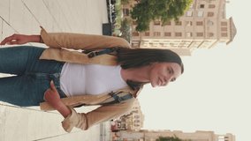 Vertical video, Traveler girl, with backpack on her shoulders, walks in the historical part of European city