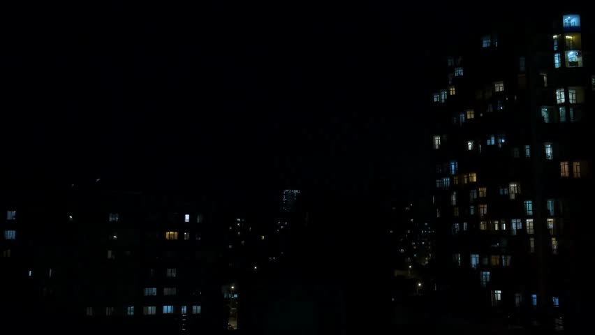 Lightning and thunder over the city at night. Lightning strikes and thunderstorm over town buildings with illuminated sky during electrical storm