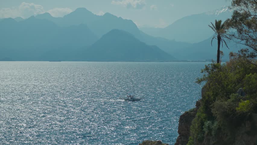 sailing yacht swim in the bay with turquoise sea water. Sailing yacht in Antalya marine port, Turkey. beautiful landcape with sea and mountains