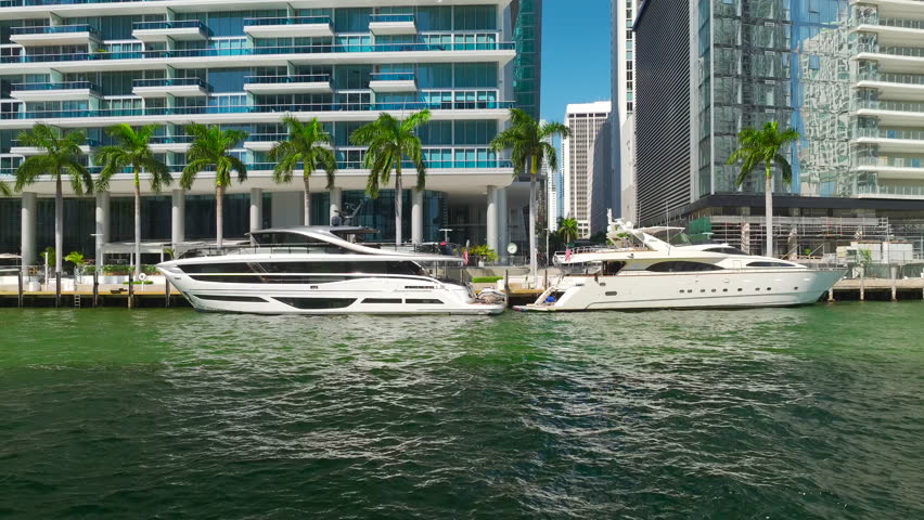 Miami Brickell in Florida, USA. View from above of luxury yachts on Miami River between concrete and glass skyscraper buildings in city downtown. American megapolis with business financial district