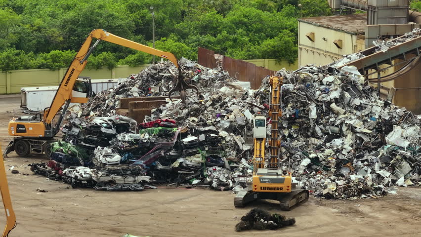 Car dump junkyard with cranes recycling old vehicle frames for scrap metal. Dismantling of crushed old automobiles at industrial scrapyard Royalty-Free Stock Footage #1109631069