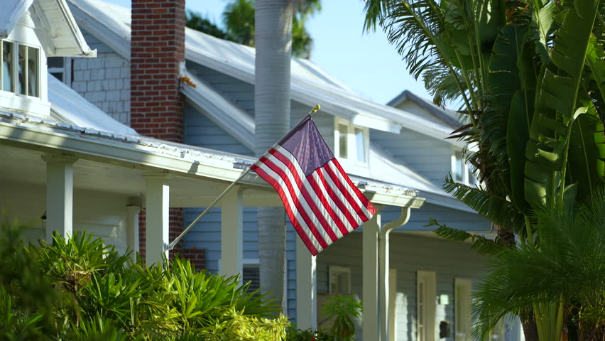 American national flag waving in front yard of Florida private house. Aerial view of USA stars and stripes spangled banner as symbol of democracy