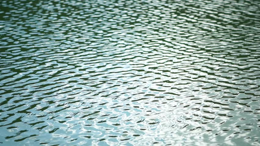 Sun reflecting on sparkling sea lake water surface, ocean at sunset, sunrise. Sunrays flickering in Ripples on water surface. Golden shimmering sea waves in sun. Slow motion. Abstract nautical nature