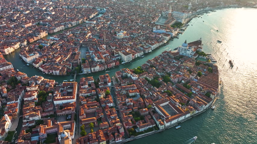 Aerial view of the Grand Canal of Venice at sunrise, Basilica di Santa Maria della Salute, St. Mark's Square, Doge's Palace, Basilica, and Campanile in the Venetian Lagoon, Italy Royalty-Free Stock Footage #1109640485