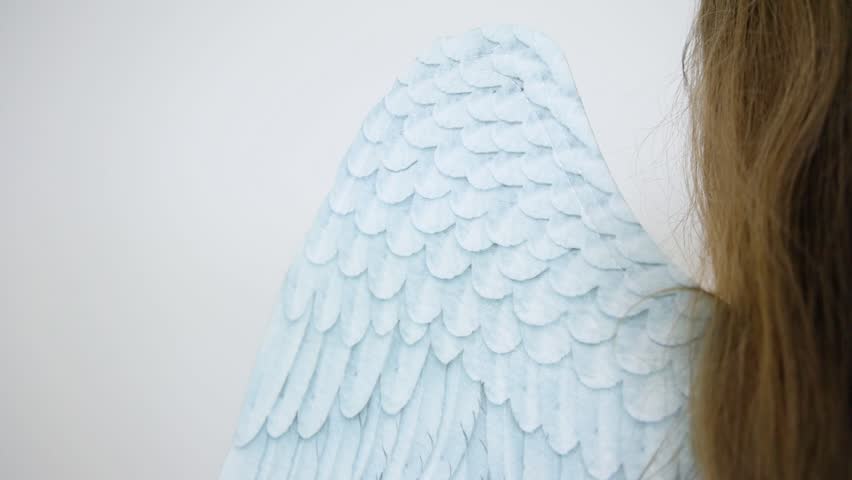 Back side of a woman in a dress wearing angel wings