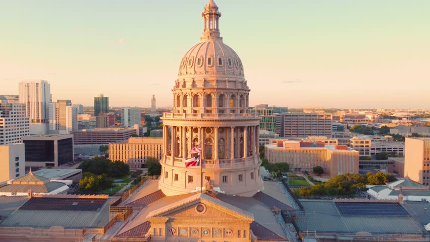 Downtown Austin, Texas State Capital Building, Aerial Drone Shot Flying over Goddess of Liberty Statue on Top with Views of The University of Texas at Austin Campus Skyline at Sunset in 4K.