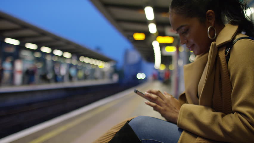 Handheld shot of attractive young female using her phone at a train station at night Royalty-Free Stock Footage #1109653029