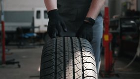 front view, the hands of a car mechanic rolling a wheel in the workshop - Powered by Shutterstock - Get 15% off with code: PIKWIZARD15
