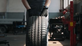 front view, the hands of a car mechanic rolling a wheel in the workshop - Powered by Shutterstock - Get 15% off with code: PIKWIZARD15