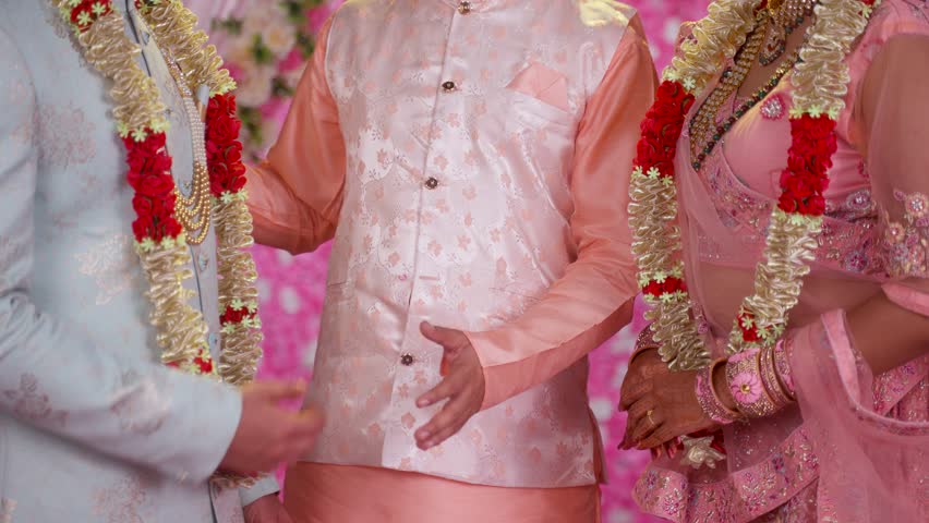 Close up shot father joining hands of newlywed bride and groom after marriage - Father giving responsibility of daughter to son in law by holding hands at wedding - concept of traditional culture. Royalty-Free Stock Footage #1109663451