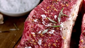Mouthwatering 4K Video: Close-Up of Raw Meat Steak Seasoned with Salt and Fresh Herbs