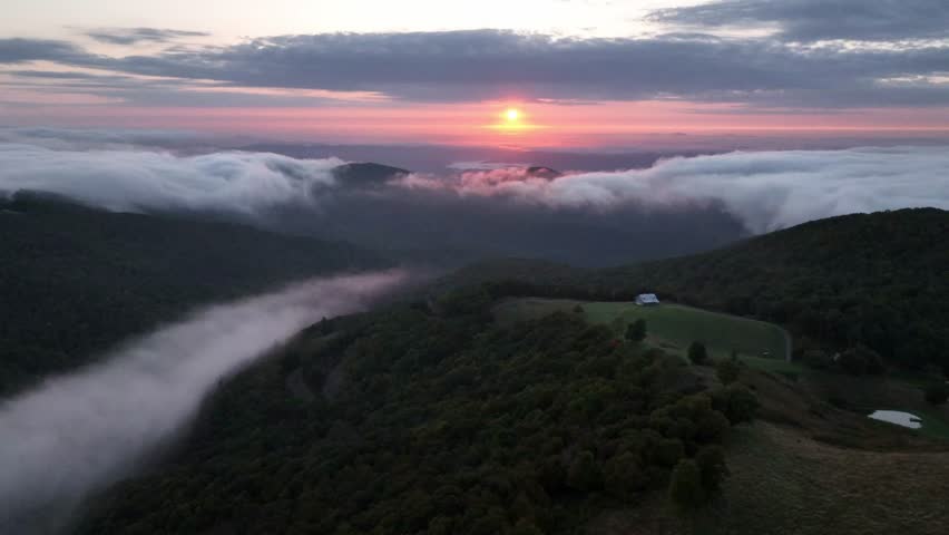 aerial orbit at sunrise with fog in the valley between boone and blowing rock nc, north carolina