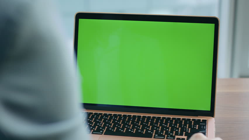 Unknown worker watching mockup laptop standing at wooden desk close up. Unrecognizable person sitting in front green screen computer at office. Company manager looking on chroma key monitor indoors. Royalty-Free Stock Footage #1109680441