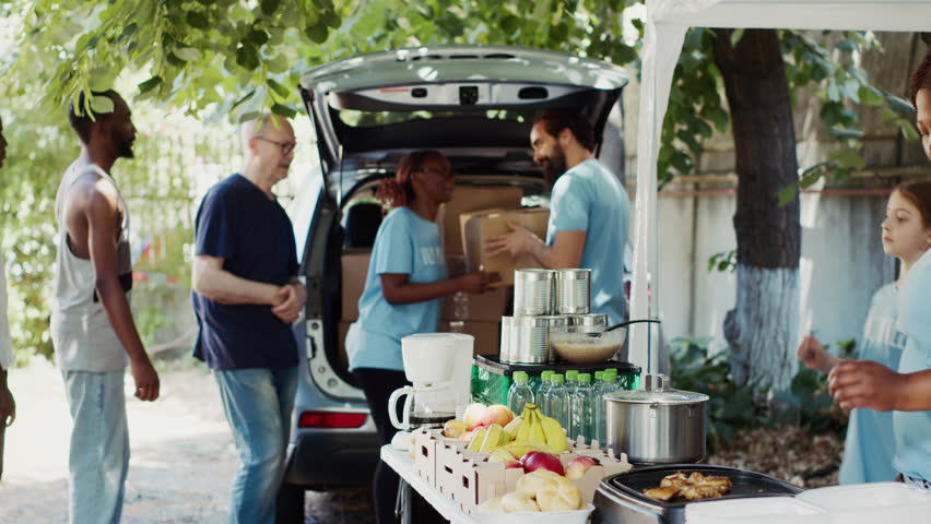 Group of volunteers handing out packed food to needy such as the elderly and homeless people. The sincere gesture of kindness makes the less fortunate individuals happy and relieves their suffering. Royalty-Free Stock Footage #1109680739