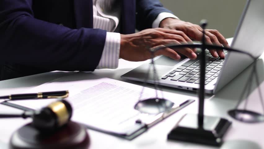 Lawyer working with laptop in law office. Online legal consulting concept.