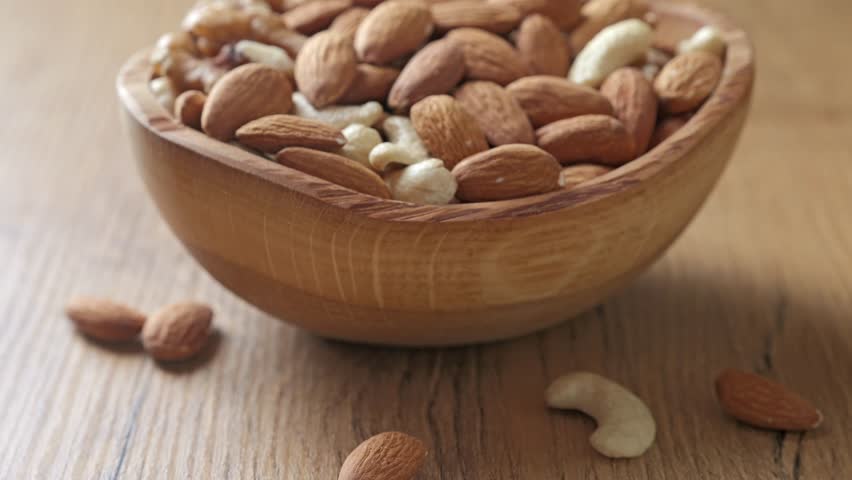 Assorted nuts of almonds, cashews, and walnuts in a wooden bowl. Healthy nutrition concept.