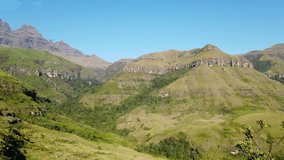 Panning view of the Drakensberg mountains with lush vegetation of summer, South Africa