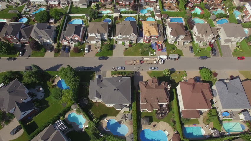 Aerial tilt up shot revealing rows of houses in beautiful residential neighbourhood during summer in Montreal, Quebec, Canada. 